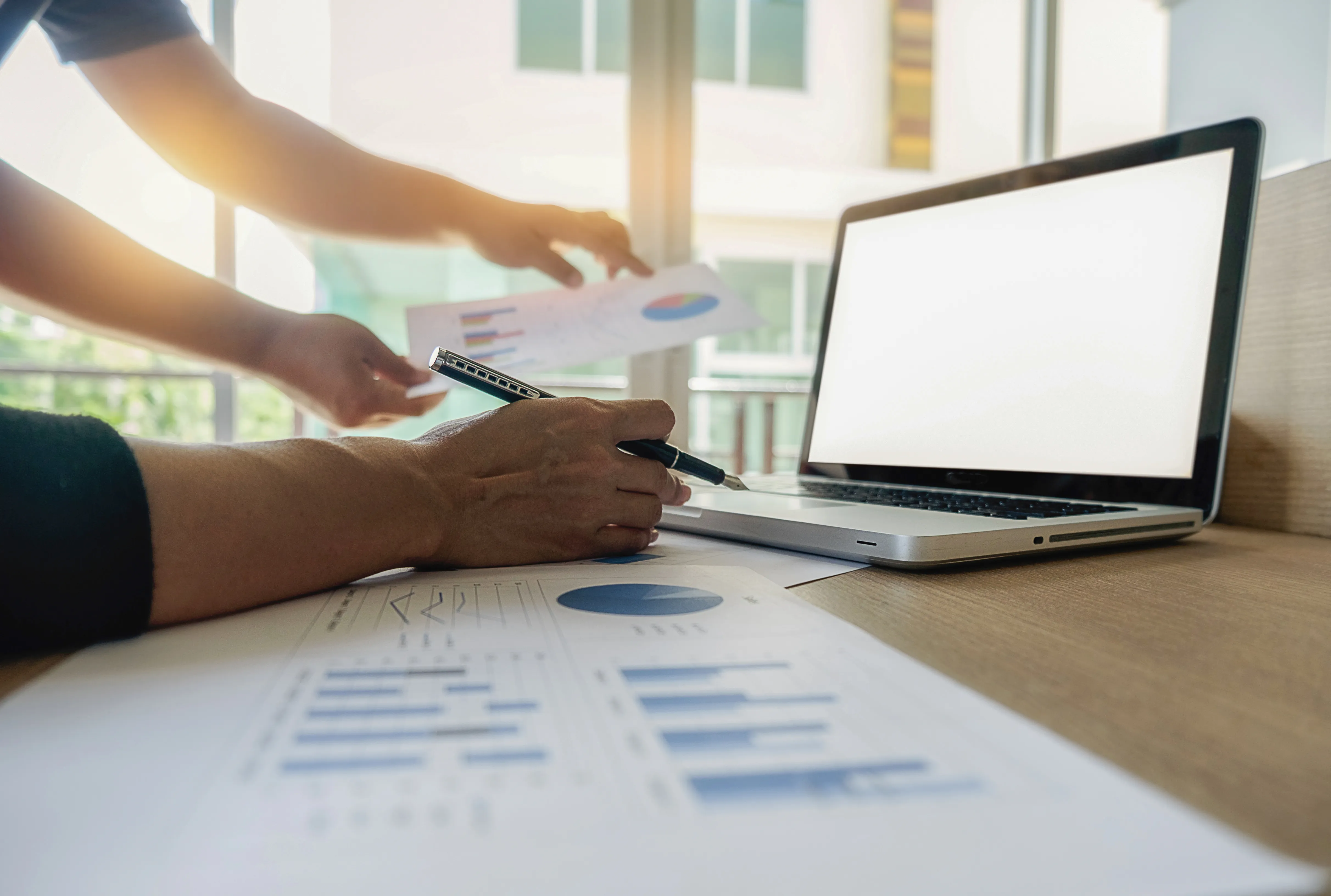 Business professionals reviewing financial reports during a cash flow forecasting discussion.